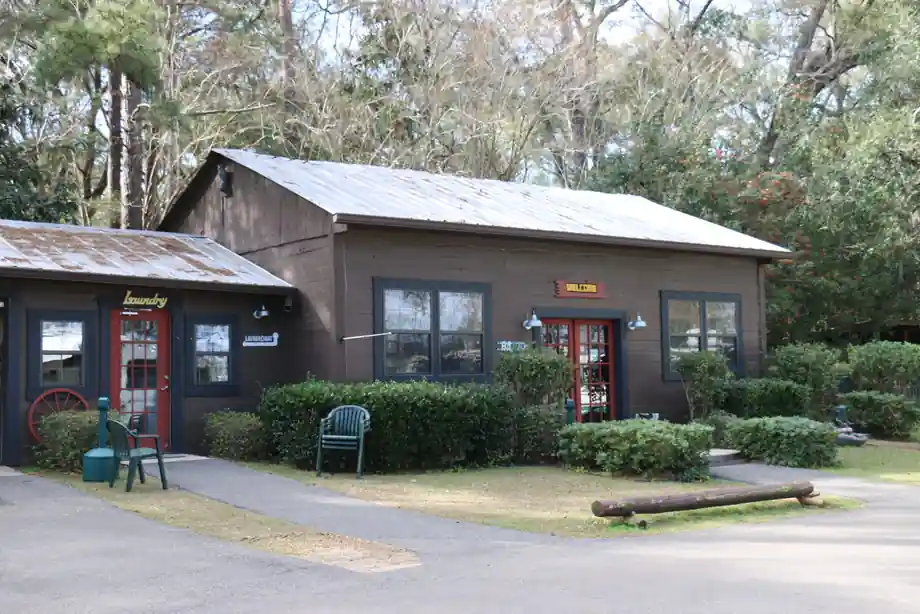 Wood-sided office cabin at the park entrance, with shrubs and a front walk