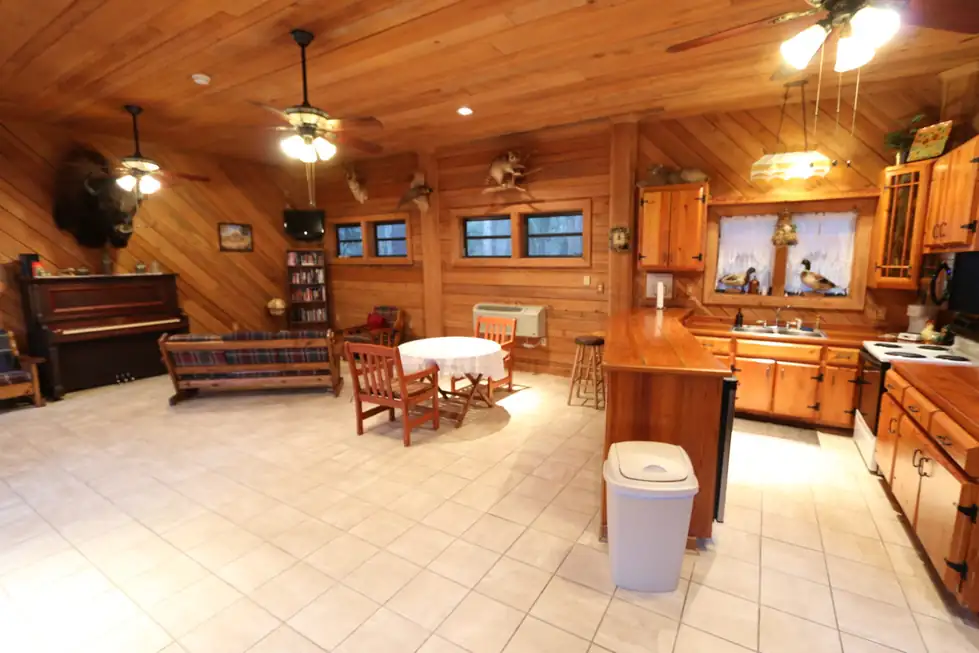 Clubhouse kitchen with pine cabinets, a long counter and a dining table