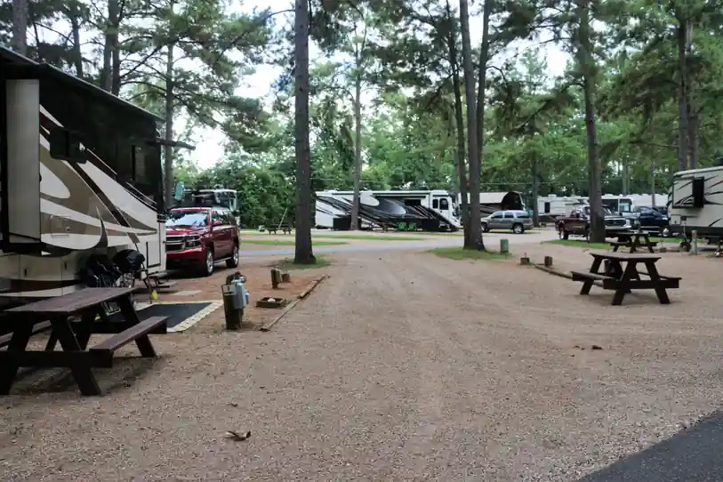 Gravel park road with picnic tables and a Class A motorhome on its site